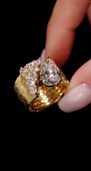 Water Drop Cocktail Ring with bold pear-cut lab sapphire and scattered stones on a textured gold band