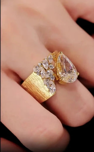 Water Drop Cocktail Ring with bold pear-cut lab sapphire and scattered stones on a textured gold band