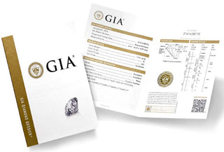 GIA-certified diamond with grading report displayed beside the stone on a jeweler’s desk.