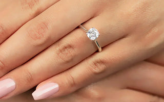 Close-up of a hand wearing an engagement ring on the left ring finger