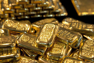 Side-by-side comparison of platinum and gold bars on a digital scale, illustrating the weight and density difference between the two precious metals.