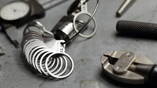 Jeweler carefully resizing a gold ring using precision tools on a workbench.