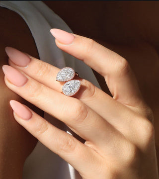 A sparkling lab-grown diamond held by tweezers beside a natural diamond, emphasizing their visual and structural similarities. 