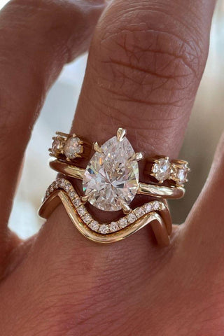 Jeweler sketching a custom ring design beside loose gemstones and tools, capturing the creative process of bespoke jewelry craftsmanship.