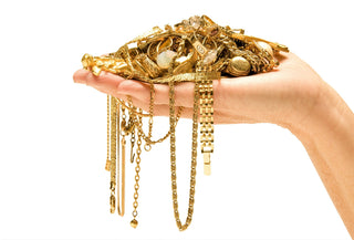 Assorted gold jewelry pieces placed on a digital scale with cash beside them, symbolizing resale, valuation, and maximizing return.