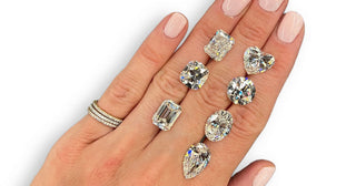Assortment of unique diamond cuts including marquise, pear, trillion, and heart-shaped stones displayed on a velvet jewelry tray.