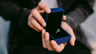 A luxurious, velvet-lined proposal ring box opened to reveal a sparkling engagement ring—capturing the emotional impact and elegance a well-chosen ring box adds to the perfect proposal moment.