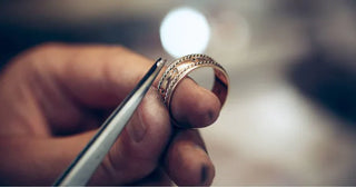 Jeweler sketching a custom ring design beside loose gemstones, showing the creative process of personalized jewelry making