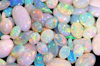 Vibrant opal ring displaying a rainbow of colors in a delicate gold setting