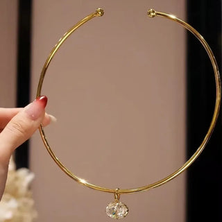 Gold-plated torque necklace with central drop-shaped lab sapphire, handcrafted in sterling silver for women, designed by Azzallure.