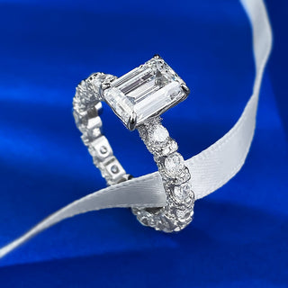 Sterling silver ring with an emerald-cut moissanite centerpiece in a classic prong setting, showcasing minimalist elegance.