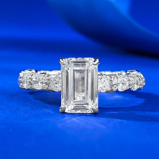 Sterling silver ring with an emerald-cut moissanite centerpiece in a classic prong setting, showcasing minimalist elegance.