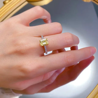Sterling silver ring with an emerald-cut moissanite centerpiece in a classic prong setting, showcasing minimalist elegance.