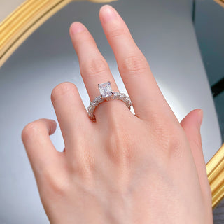 Sterling silver ring with an emerald-cut moissanite centerpiece in a classic prong setting, showcasing minimalist elegance.