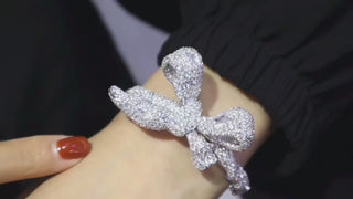 Empress Bow Bangle in 925 sterling silver, designed as a sculpted bow encrusted with white lab sapphires for a bold, couture-inspired look.